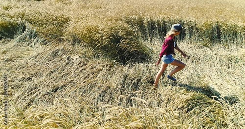 Wallpaper Mural sexy frau mit hut und kurzen jeans und sonnenbrille geht durch roggenfeld im sommer Torontodigital.ca