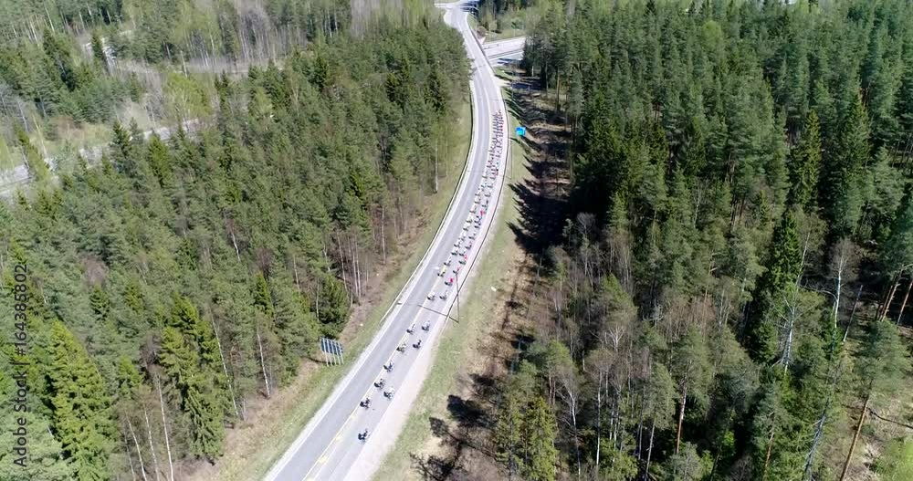 Bicycle race, Cinema 4k aerial view following a group of cyclists, racing over road e18 on a cycle event, on a summer day, just outside Nuuksio national park, in Espoo, Finland Bicycle race, Cinema 4k aerial view following a group of cyclists, racing over road e18 on a cycle event, on a summer day, just outside Nuuksio national park, in Espoo, Finland