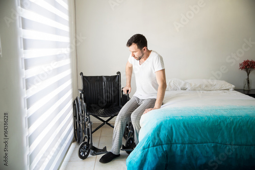 Man trying to sit on his wheelchair