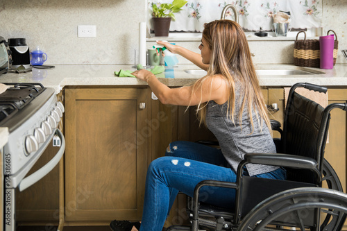 Woman in wheelchair cleaning the kitchen