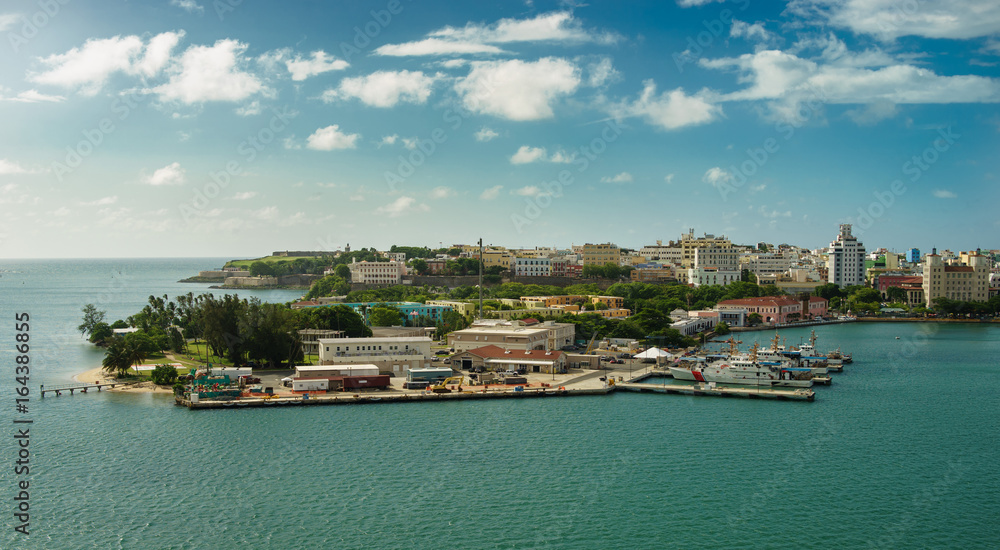 Scenic view of historic colorful Puerto Rico city in distance with fort in foreground