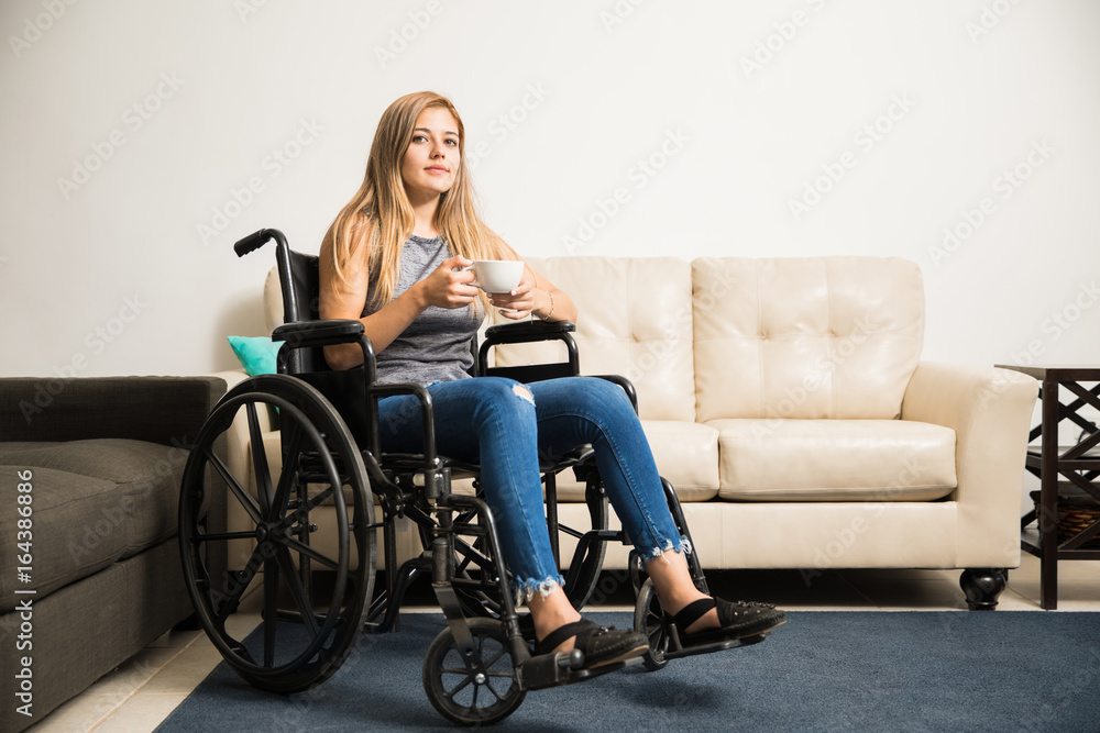Sad woman on wheelchair relaxing at home Sad woman on wheelchair relaxing at home