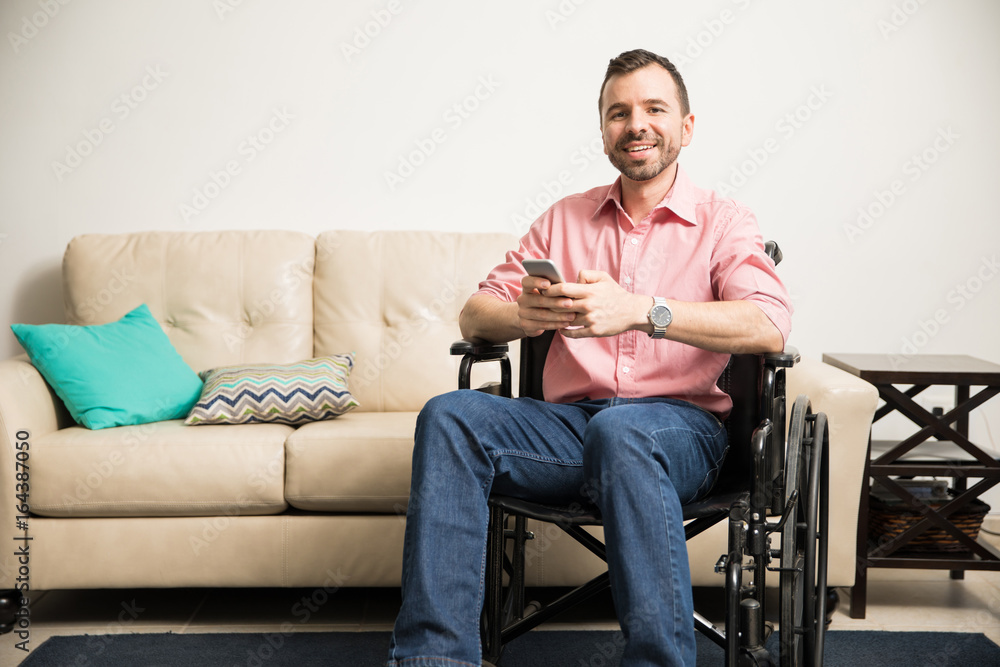 Happy man on wheelchair with a phone