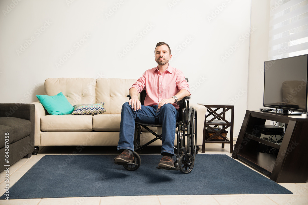 Sad man on a wheelchair at home