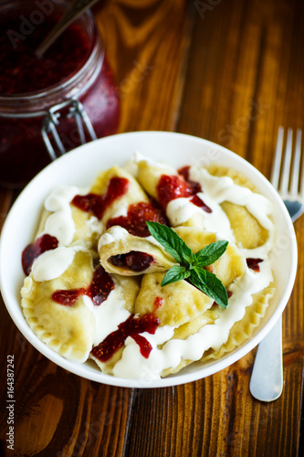 Homemade sweet dumplings with berries and sour cream