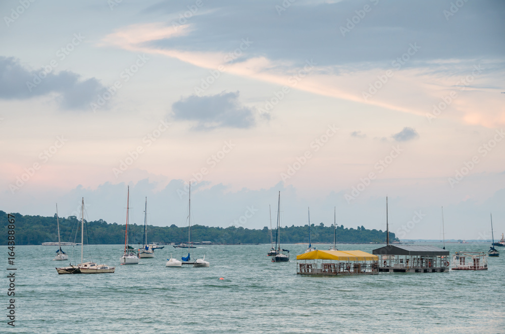 Changi, Singapore - April 30, 2017: Small private yacht anchored along the Changi Boardwalk span a 2.2 km and includes a jogging track, fitness corners, rest areas and car park for visitors. Changi, Singapore - April 30, 2017: Small private yacht anchored along the Changi Boardwalk span a 2.2 km and includes a jogging track, fitness corners, rest areas and car park for visitors.