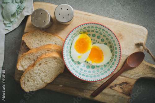 boiled eggs with white bread for healty breakfast on a old table photo