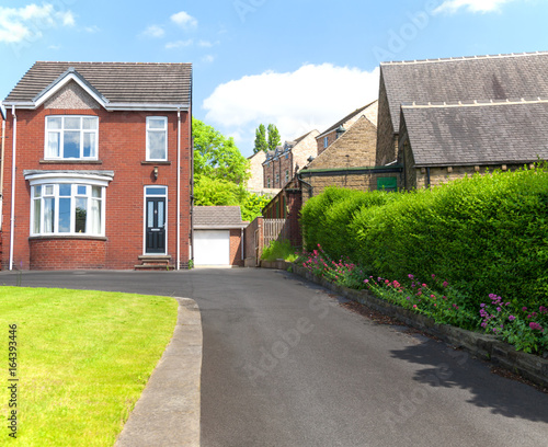 Typical english single family house built of red bricks, with a large driveway