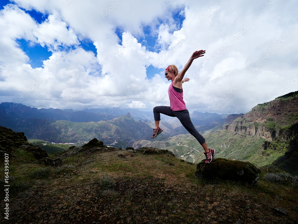 young happy woman jumping on top of the mountain young happy woman jumping on top of the mountain