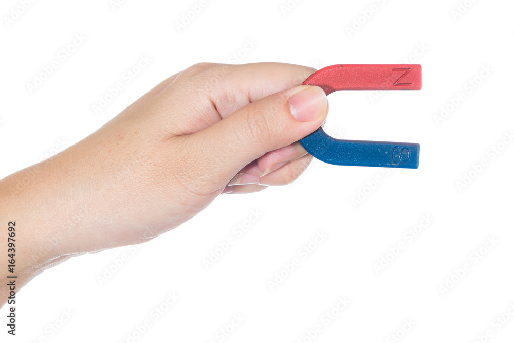 Female hand holding red and blue magnet isolated on white background Female hand holding red and blue magnet isolated on white background