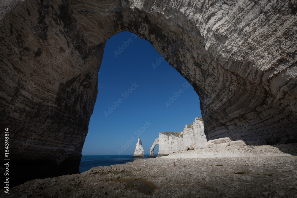 Looking through the Manneporte arch towards the Porte d'Aval and L'Aiguille at Etretat, a commune in the Seine-Maritime department in the Normandy region of north western France