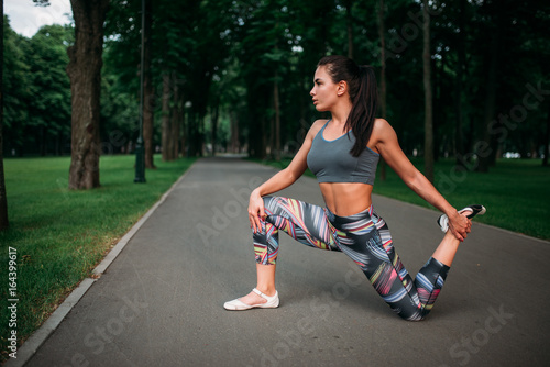Athletic woman exercises, fitness training in park