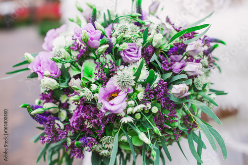 Beautiful purple wedding bouquet in bride's hands