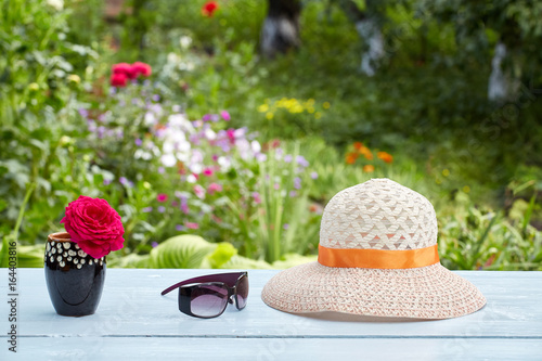 Fototapeta Naklejka Na Ścianę i Meble -  Vase with flower and summer sunglasses and hat