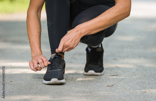 runner woman tie shoe in a park