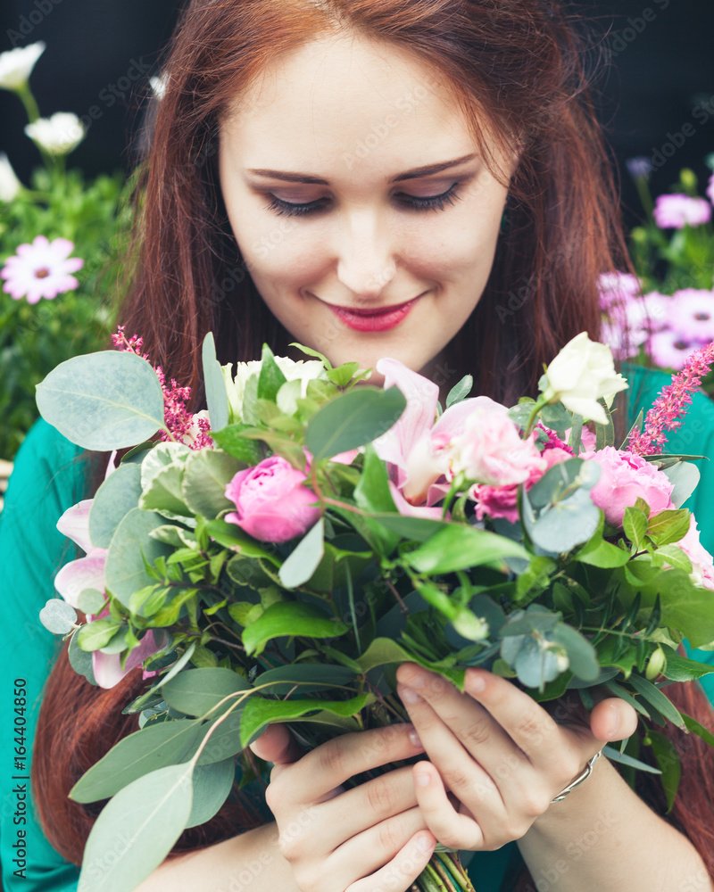 Fototapeta premium Street portrait of a young serene girl with a bouquet of flowers.