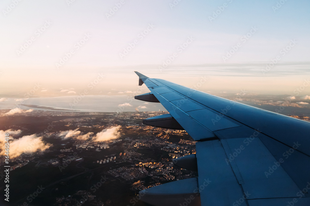 Fototapeta premium View from airplane window above evening Lisbon with few clouds b