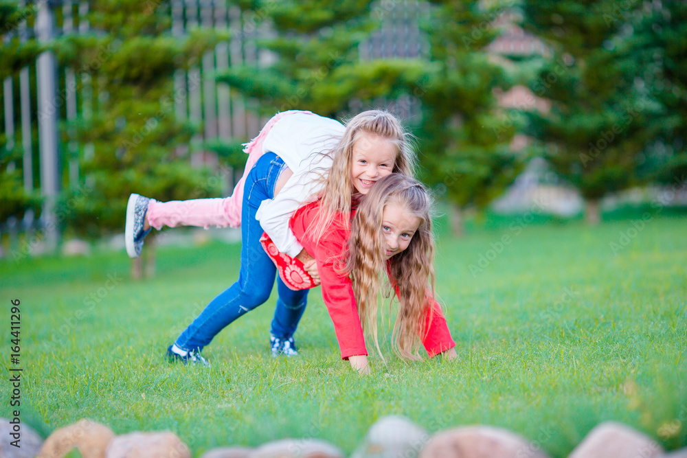 Little happy girls have a lot of fun outdoors in the park Little happy girls have a lot of fun outdoors in the park