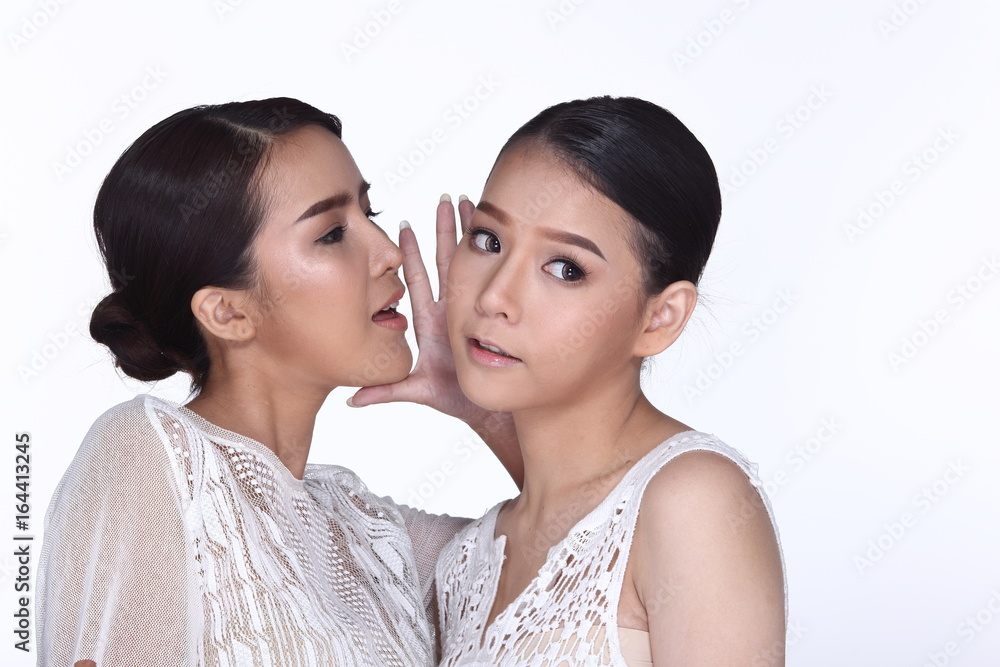 Two beautiful lovely sisters sharing a secret together by whispering man things, Two beautiful lovely sisters sharing a secret together by whispering man things,