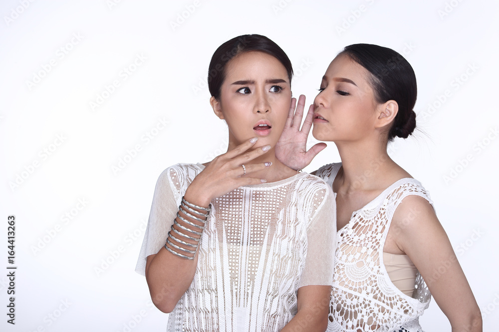 Two beautiful lovely sisters sharing a secret together by whispering man things, Two beautiful lovely sisters sharing a secret together by whispering man things,