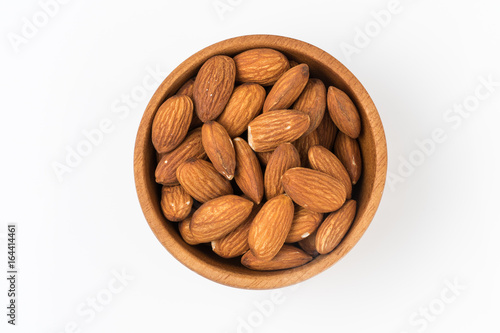 Almond in wooden bowl isolated on white background. Top view