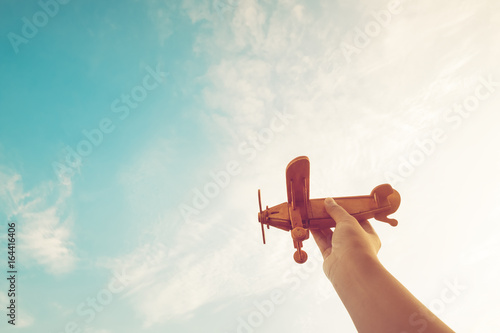 Childhood inspiration - Hands of children holding a toy plane and have dreams wants to be a pilot - Vintage filter effect