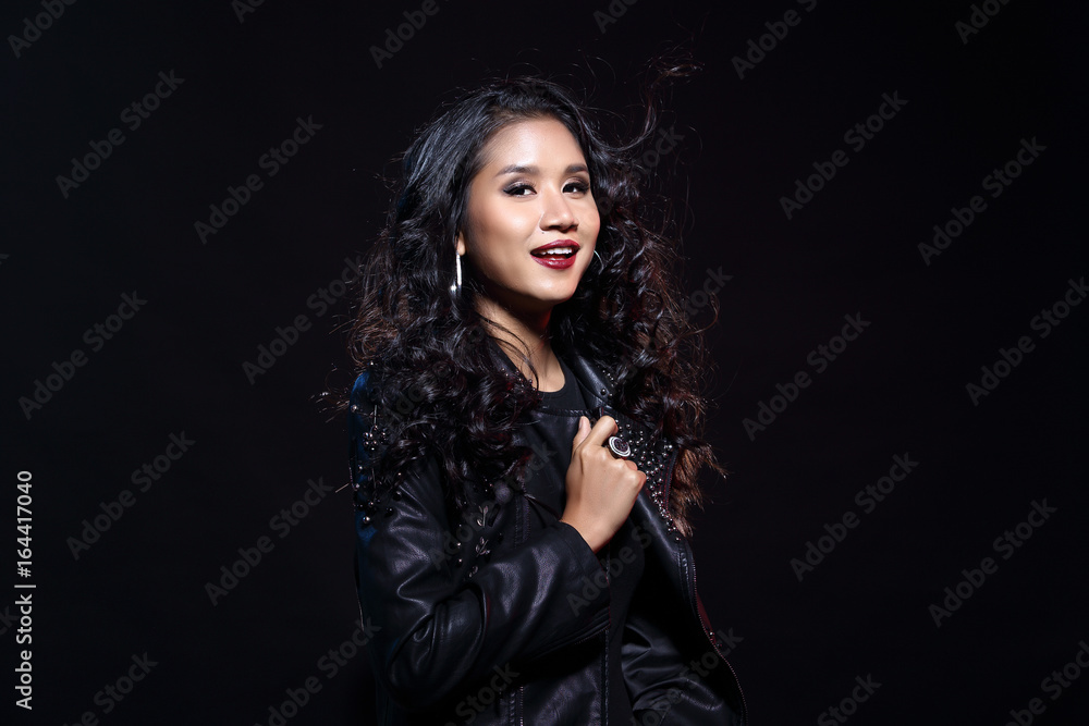 low key portrait of tan skin asian slim healthy woman in black background