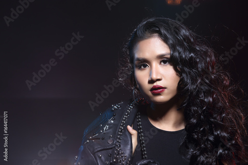 low key portrait of tan skin asian slim healthy woman in black background