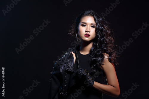 low key portrait of tan skin asian slim healthy woman in black background