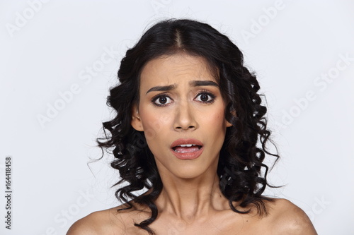 Tan Skin Curl Hair Asian Woman open shoulder express feeling on face and eyes, question, curious, what, half body studio lighting gray background, copy space