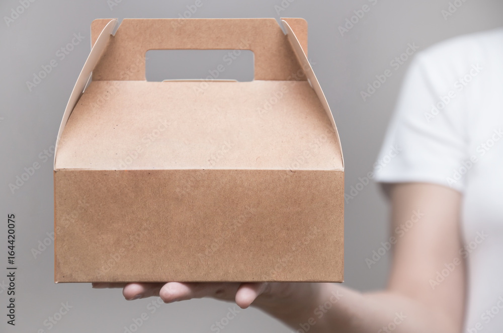 A woman in white T-shirt stood bringing a snack box - obrazy, fototapety, plakaty 