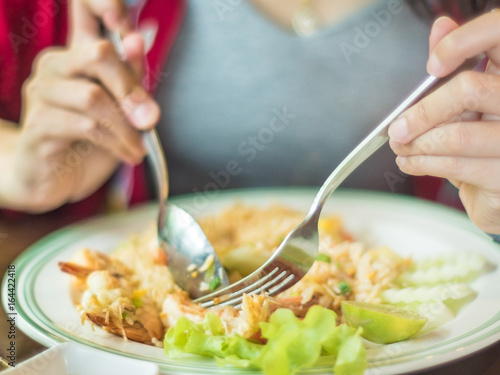 Closeup of woman eating fried rice in restaurant.