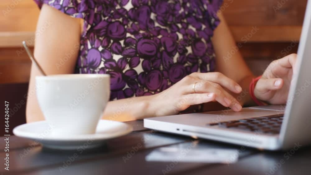 Anonymous woman working with laptop in a cafe. Close-up. Anonymous woman working with laptop in a cafe. Close-up.