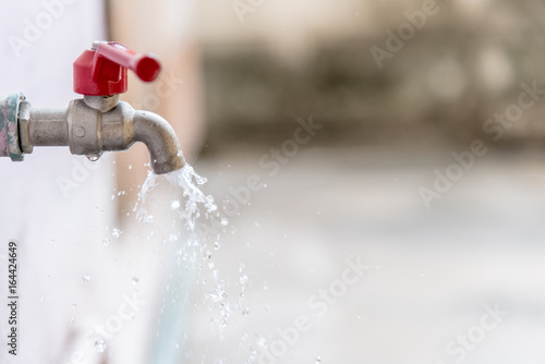 Closeup Tap with dripping water-drop. Saving water.