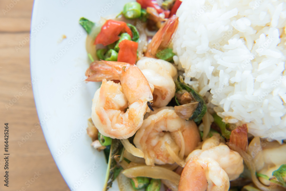 Stir-Fried Shrimps and Basil Rice Thai Food style has ready to served on white plate. Stir-Fried Shrimps and Basil Rice Thai Food style has ready to served on white plate.