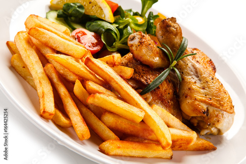 Roast chicken leg with french fries on white background 