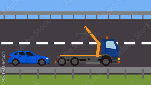 Tow truck picking up a vehicle on the road