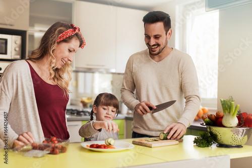 Young family preparing salad together