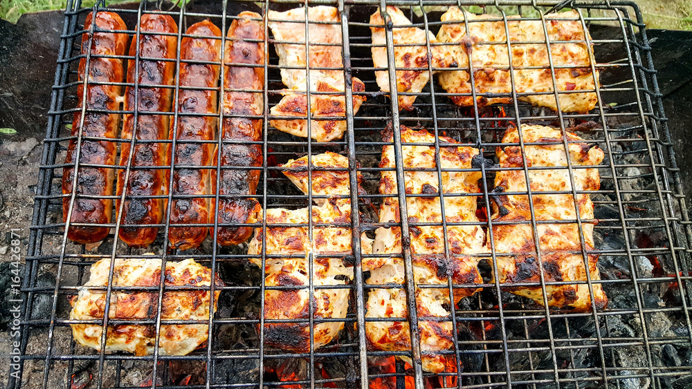 Cooking juicy and delicious pork, beef and chicken in the grill during summer vacation