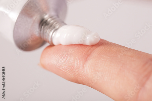 Close up image of hands with cream tube photo