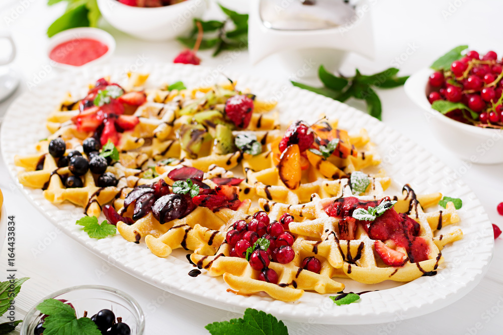 Variety of Belgian wafers with berries, chocolate and syrup. Variety of Belgian wafers with berries, chocolate and syrup.
