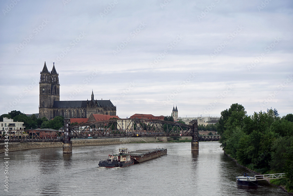 Blick über die Elbe auf Magdeburg mit Dom und Transportschiff