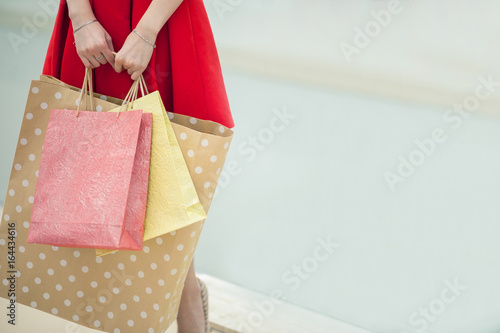 After day shopping. Close-up of young woman carrying shopping bags while walking along the street photo