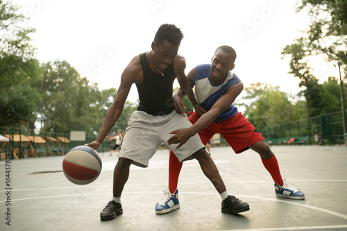 African american man friends playing on basketball court. Real authentic activity. © antgor