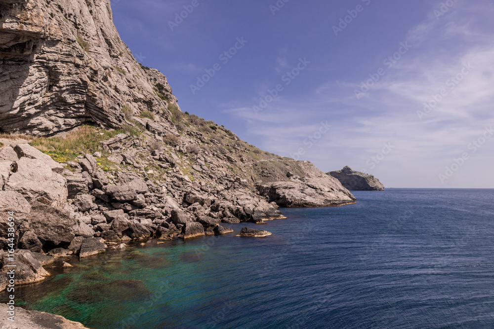Amazing view on black sea near rocks in hot summer. Vacation, summer travel. Rocks in the Black Sea. Crimea
