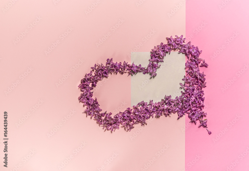 Heart of flowers of lilac. Background for a site design or landing page about food, health, flowers and spring. Layout on a pink background. A place for your inscriptions. The geometry of paper. Heart of flowers of lilac. Background for a site design or landing page about food, health, flowers and spring. Layout on a pink background. A place for your inscriptions. The geometry of paper.