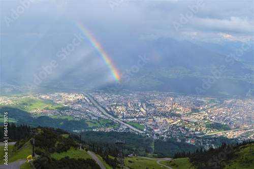 Stadt mit Regenbogen in den Alpen