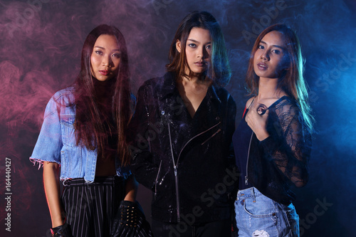 Three Models, low key portrait of slim healthy woman in black background with fog smoke and light from back