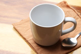 white cup and spoon on wood floor