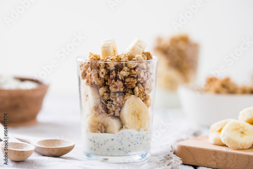 Chia pudding parfait, layered yogurt with banana, granola. Healthy breakfast